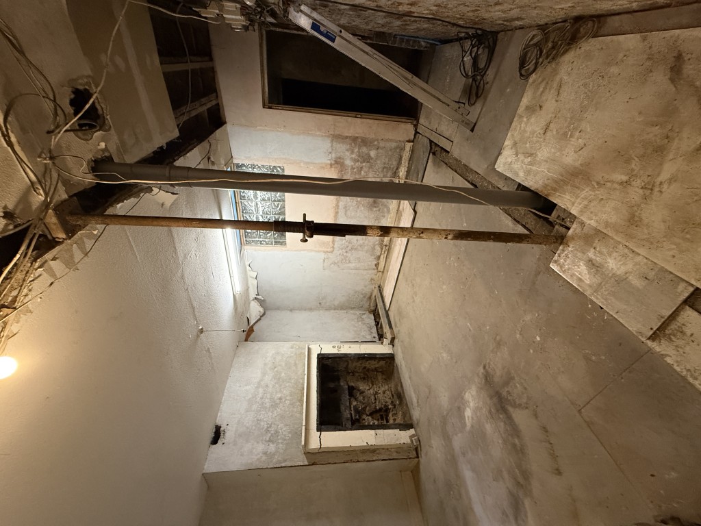 Lot: 82 - MIXED RESIDENTIAL AND COMMERCIAL BUILDING WITH POTENTIAL - Basement room with support beams and fireplace